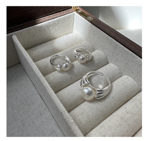 Macro detail of S925 sterling silver pearl ring and earrings set in a jewelry box