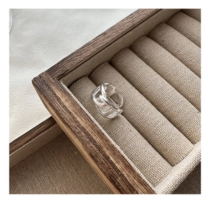 Macro shot of silver pig-nose ring showing multi-layer geometric hollow design on wood