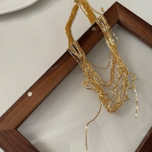 Elegant gold S925 sterling silver multi-layered tassel chain necklace displayed on wood