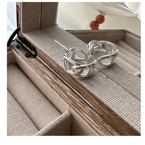 Detailed macro view of S925 sterling silver anchor link rings in a beige jewelry box