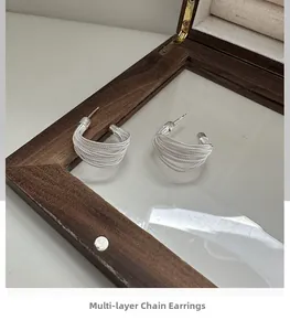 Macro view of multi-layer silver wire earrings with C-shaped curved design