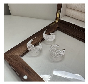 Detailed view of S925 sterling silver woven earrings in a vintage wooden jewelry box