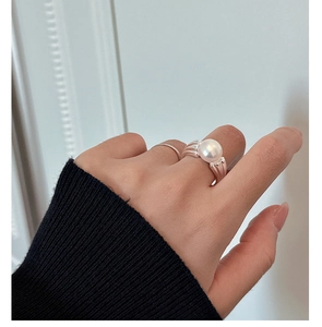 Close-up of elegant S925 silver wavy ring with a large white round pearl on finger
