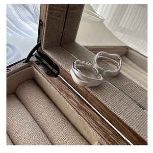Detail of S925 sterling silver double-layer liquid style ring in wood jewelry box