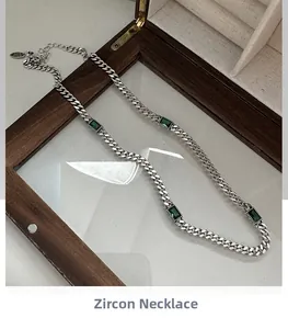 Close-up of S925 sterling silver chain with emerald green zircon in a wooden box