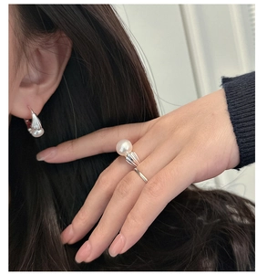 Detailed view of elegant S925 silver ring and earrings with pleated shell textures and pearls