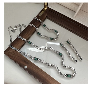 Macro view of S925 silver Cuban link necklace with emerald green rectangular zircon