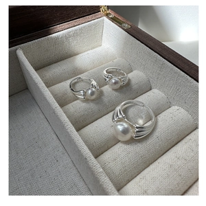 Detail of S925 silver pearl rings set in a vintage shell design on jewelry box display