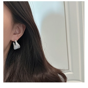 Close-up of S925 sterling silver multi-layer woven C-shaped earrings worn by a model