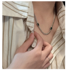 Detail view of S925 silver Cuban chain necklace with emerald green zircon stones