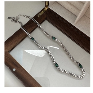 Detail of S925 sterling silver cuban chain necklace with green zircon gemstone inlays