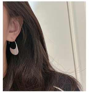 Close-up of matte brushed S925 sterling silver half-moon ear hook on ear