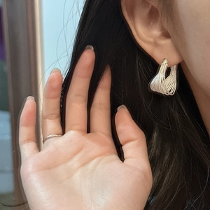 Modern S925 sterling silver multi-layered arc earrings worn by model with minimalist gold ring