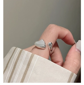 Macro shot of minimalist S925 sterling silver irregular heart-shaped open ring on finger