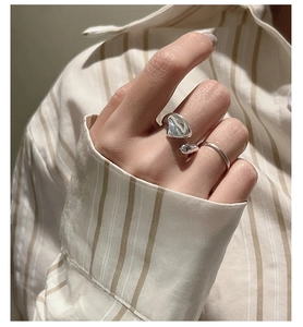 Detail of minimalist S925 sterling silver liquid lava open ring with polished metal finish