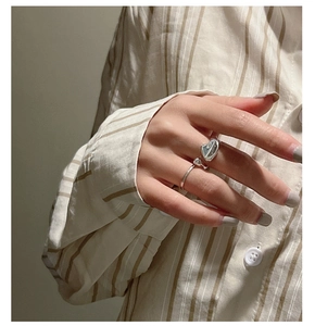 Close-up of S925 sterling silver ring with irregular liquid metal texture on finger