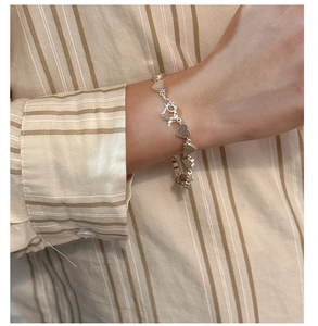 Detail of S925 sterling silver heart-linked bracelet worn on wrist with elegant clasp