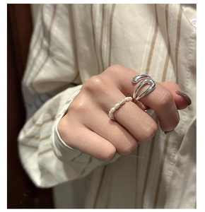 Detail of S925 sterling silver U-shaped ring and freshwater pearl stack on finger
