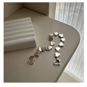 Macro view of S925 sterling silver heart-shaped linked bracelet with matte finish