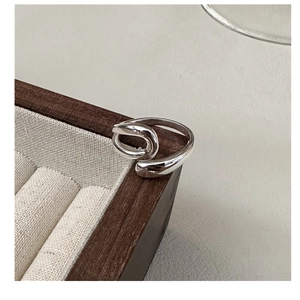 Close-up of S925 sterling silver U-shaped intertwined ring on a jewelry display box