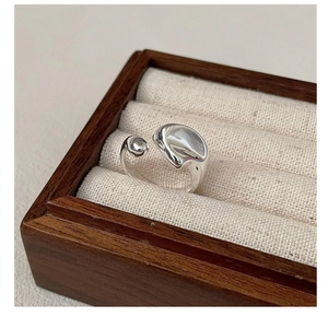 Macro view of minimalist irregular fluid S925 silver ring on a vintage jewelry box