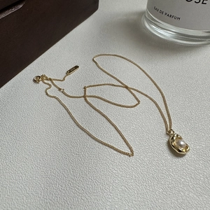 Elegant S925 sterling silver gold pea necklace with white pearl on marble background