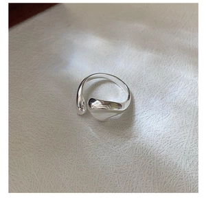 Macro shot of minimalist irregular fluid S925 sterling silver ring with polished finish