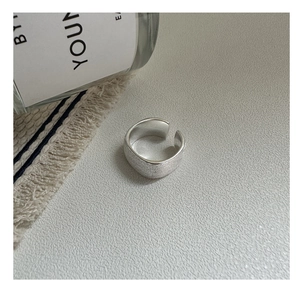 Détail macro d'une bague réglable en argent avec une finition mate brossée minimaliste