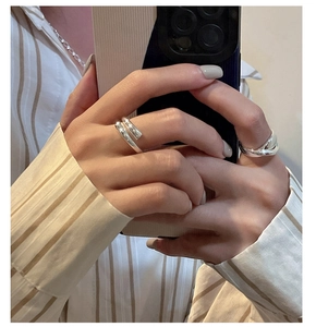 Detail of S925 sterling silver crossover rings on hand showing smooth mirror finish