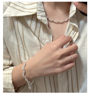 Detailed close-up of S925 silver necklace and bracelet set with irregular lava texture