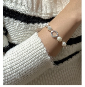 Detailed view of S925 silver irregular pearl bracelet worn on wrist with knit sweater
