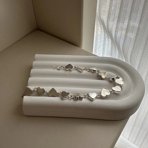 Elegant S925 sterling silver heart-shaped chain bracelet with matte finish on display stand