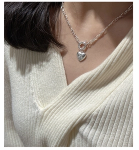 Close-up of S925 sterling silver heart necklace with starburst engraving and textured chain