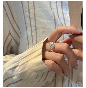 Detail view of a minimalist S925 sterling silver crisscross ring on a hand