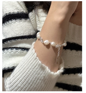 Detailed close-up of S925 silver bracelet featuring baroque pearls and a rectangular tag