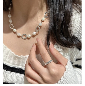 Macro view of S925 silver necklace with irregular freshwater pearls and wavy silver ring