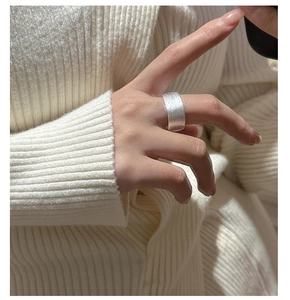 Gros plan d'une bague carrée en argent S925 avec texture brossée portée au doigt