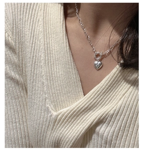 Close-up of S925 silver heart necklace with star engraving and toggle clasp on neck