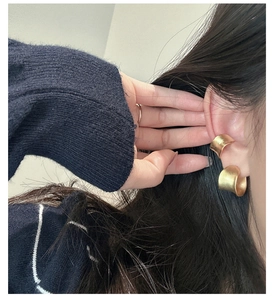 Macro detail of matte gold ear cuffs set showcasing sleek minimalist texture on the ear