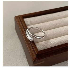 Detailed close-up of a S925 sterling silver crisscross ring with a polished mirror finish