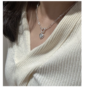 Close-up of S925 sterling silver heart necklace with star engraving and toggle clasp