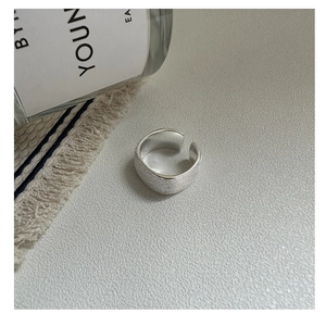 Gros plan d'une bague large en argent S925 brossé mat avec surface interne lisse