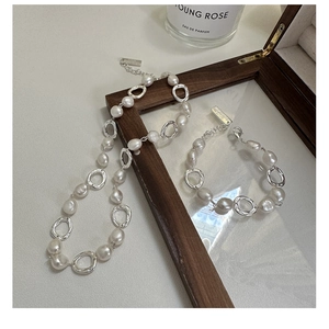 Macro detail of S925 silver necklace with irregular freshwater pearls and metallic rings
