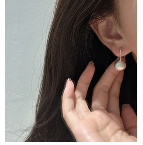Close-up of minimalist S925 sterling silver sphere earrings with a matte frosted finish