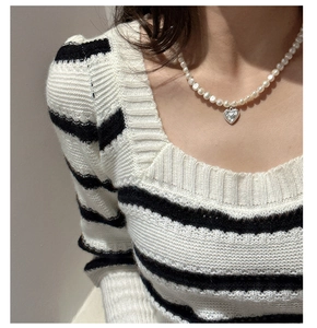 Gros plan détaillé du pendentif cœur en argent S925 et du collier de perles sur modèle