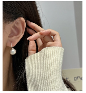 Detail of elegant S925 silver earring with a large matte pearl on a female model