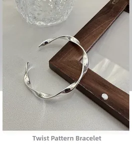 Detailed close-up of S925 sterling silver twisted bangle showing a polished wavy texture