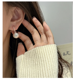 Close-up of S925 sterling silver frosted ball earrings worn by model with matte finish