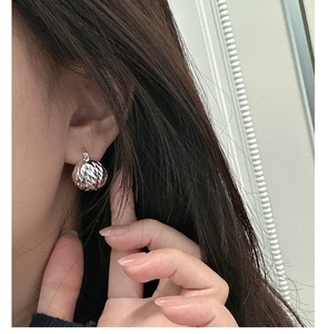 Detailed view of shimmering S925 sterling silver ball earrings with laser cut texture