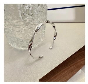 Detail shot of the S925 sterling silver stamp on a minimalist twisted wave bangle